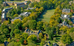 Aerial view of historic and old campus showing brick buildings, and open sunken garden and tree lined paths.