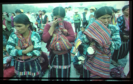 Slide 6: Three women, wearing native Guatemalan dress, crying.
