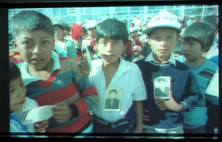 Slide 9: A group of boys, holding photographs of their lost fathers.