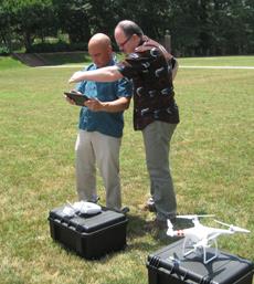 It takes two to use a quadcopter for research—one to fly the device (using the controller on the case) and a second to work a tablet, used for switching functions and monitoring the on-board camera. Gerard Chouin gives Sean Pada a little shade to get things started. Photo by Joseph McClain