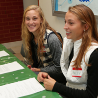 Soccer players Haley Kavanaugh (R) and Corinne Giroux registered volunteers at the toy and clothing distribution.