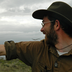 Jack Boyle, a Mellon Postdoctoral Fellow of Environmental Science and Policy at William & Mary, poses with a grass-mimicking stick insect in the Kenyan savanna.  (Photo courtesy Jack Boyle)