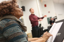 Composer Jeraldine Herbison concentrates on fine-tuning as Visiting Director of Choirs Miles Canaday directs a choir rehearsal of the song she wrote. (Photo by Stephen Salpukas)