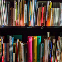 A bookshelf containing many books of various sizes and colors