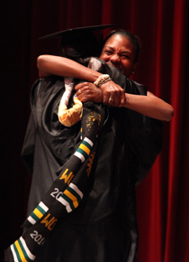 A graduate and loved one embrace during the 2014 Donning of the Kente ceremony. (Photo by Stephen Salpukas)
