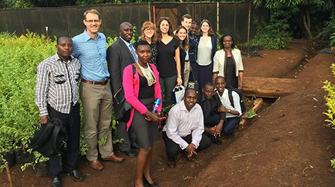 A team of students and faculty pose while touring the tour of Chuka University research garden. 