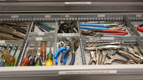 Tool drawer showing labeled compartments full of wrenches, screwdrivers, pliers