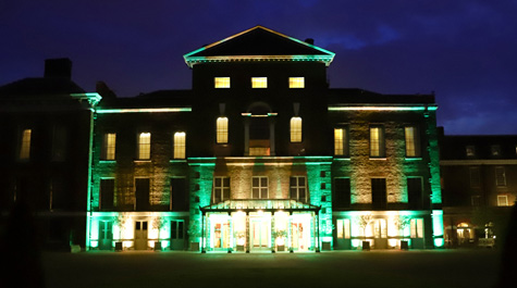 Gold and green lights shine on Kensington Palace at night