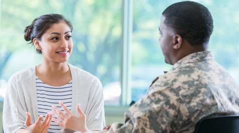 A counselor talks with a member of the military