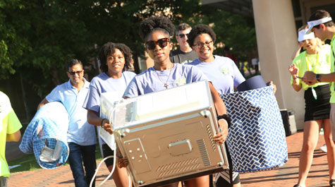 Student volunteers move new students' belongings