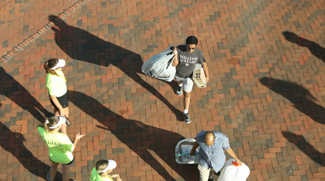 Aerial view of two people moving items into dorms