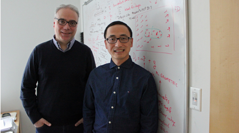 Enrico Rossi and Xiang Hu stand in front of a whiteboard