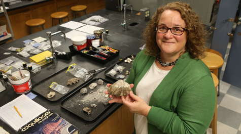 William & Mary archaeologist Jennifer Kahn examines artifacts from one of her numerous excavations of human sites in the islands of Oceania.