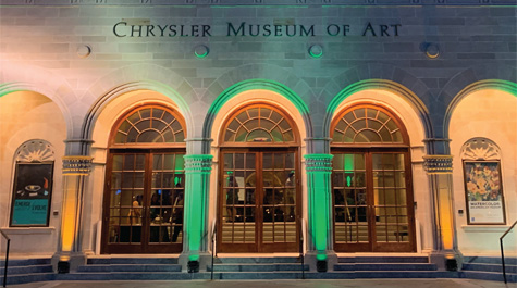 Green uplighting illuminates the entrance of the Chrysler Museum at night