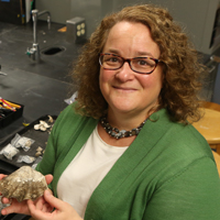 William & Mary archaeologist Jennifer Kahn examines artifacts from one of her numerous excavations of human sites in the islands of Oceania.