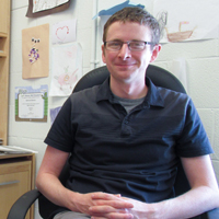Physicist Justin Stevens is pictured sitting in his office at Small Hall at William & Mary