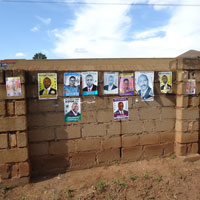 Brick wall papered with Uganda election posters