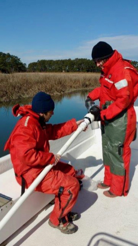 Semedo and fellow Ph.D. student Kenneth Czalpa collect a sediment sample from a tidal creek on Virginia's Eastern Shore. Semedo designed his study to sample during all seasons, including the chill of winter. (Photo by S. Fate/VIMS ESL)