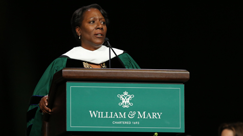 Christy Coleman dressed in academic regalia at a podium