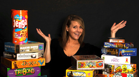 Michele King surrounded by piles of board games