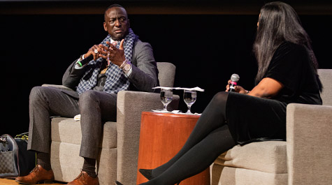 Yusef Salaam talks with Stephanie Walters while both are seated on a stage