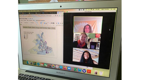 Laptop with screen showing graphic of Virginia map on left side and three women videoconferencing on right side
