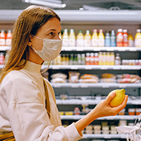 Woman grocery shops while wearing a face mask
