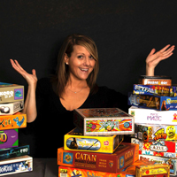 Michele King surrounded by a pile of board games