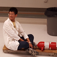 physics student holding a fire extinguisher 