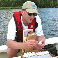 Dr. Brush samples nutrients from the New River Estuary, N.C., as part of a project funded by the Department of Defense.