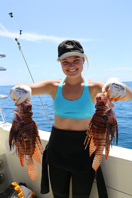 Erin Spencer ’14 holds a pair of lionfish.