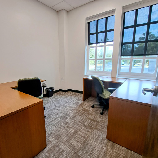 Windowed office with two large desks