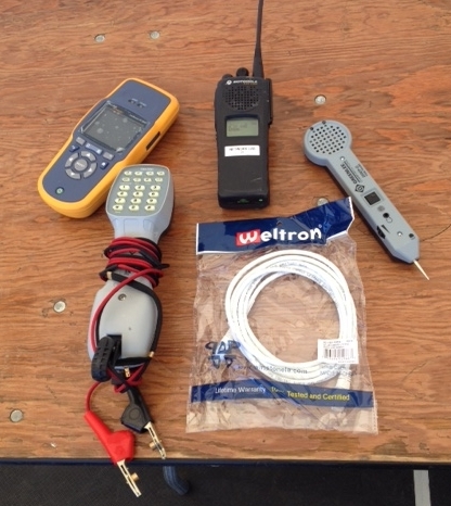 Some of the tools IT uses to prepare for the game (clockwise): a radio for communication, a toner pick-up (phones), a patch cord (network), phone test set, and a fluke network tester. 