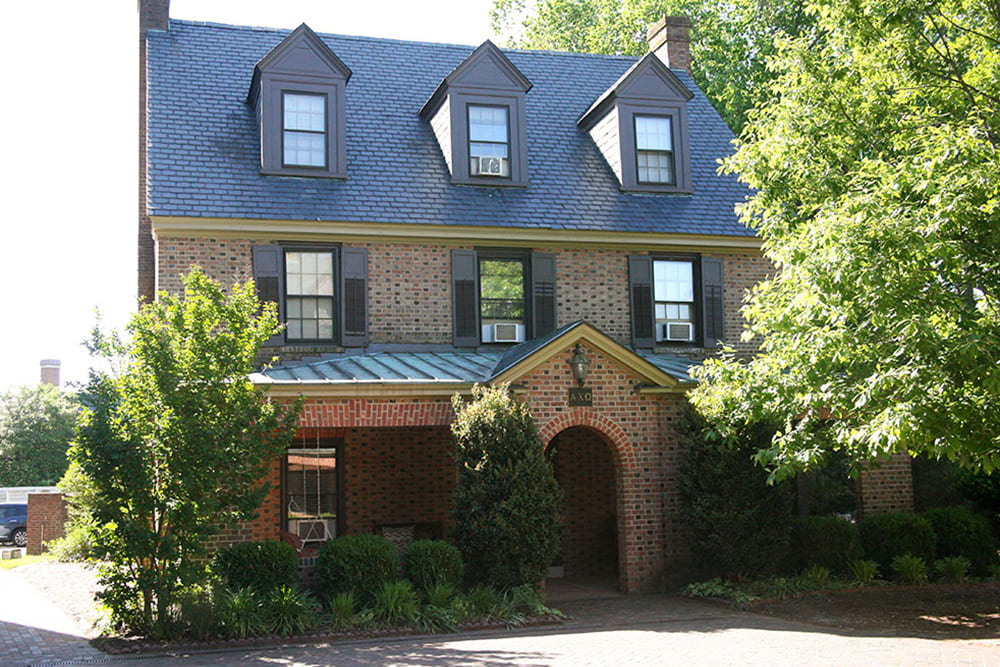 Brick house with dormer windows, slate and copper roof and front porch