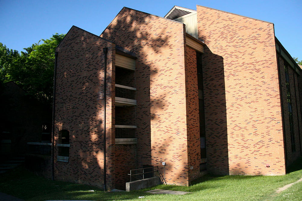 A layered three story brick building with open stairwells