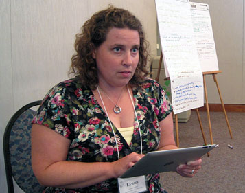 Lynsey LeMay checks the program agenda between presentations