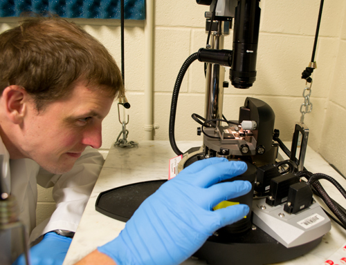 Sean Kobeley adjusts an atomic force microscope used in the molecular study of silk. Atomic force microscopy is a specialty of the lab of Hannes Schniepp. 