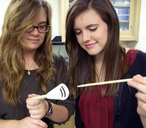 Jill Lineburg (left) and Erin Roberts examine the structure of one of the fish-inspired models being tested in Professor Laurie Sanderson’s lab.