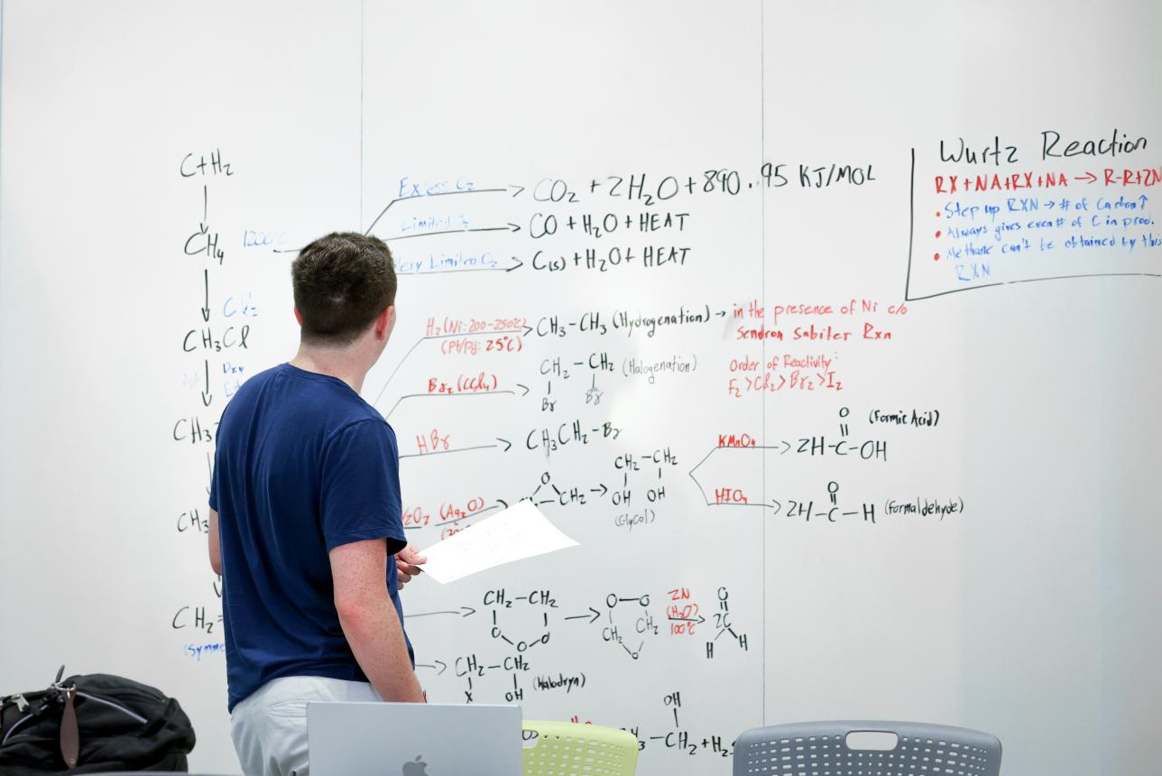 William & Mary organic chemistry student writing equations on a whiteboard