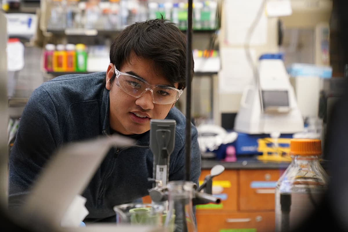 Undergraduate student wearing goggles in a chemistry lab