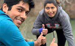 Abhi Chadha and a friend both in exercise attire smiling in exhausted fun and giving thumbs up.