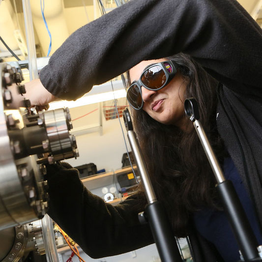 Student in goggles working equipment in a lab