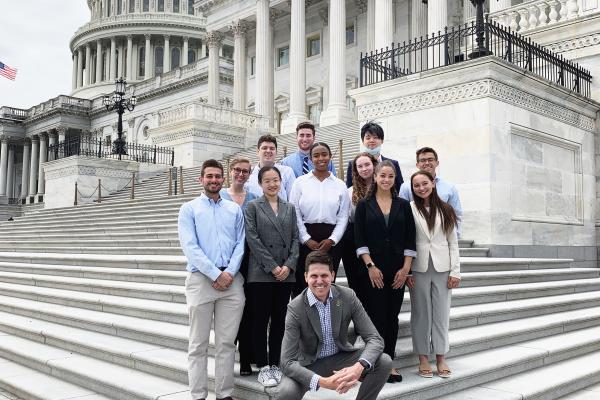 Students smiling and standing on the steps of the Capitol building