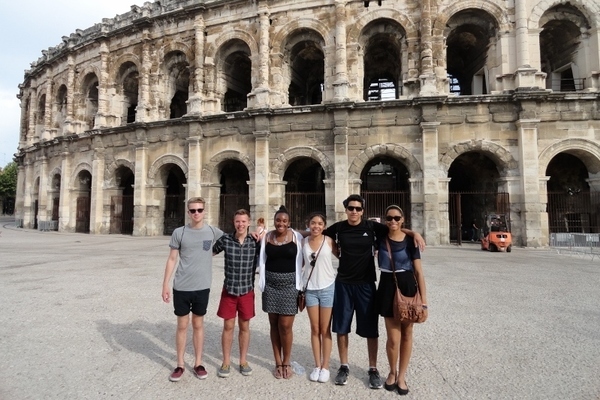 Six students pose in front of the Colosseum in Rome
