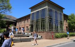 students walking in front of modern red brick building