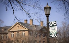 A Year of Civic Leadership banner hangs from a lamppost in front of a brick building.