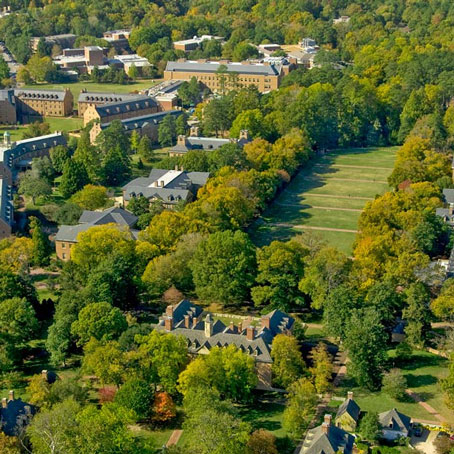 Aerial shot of campus with green trees and brick buildings.