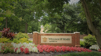Brick William &amp; Mary sign surrounded by flowers and green trees