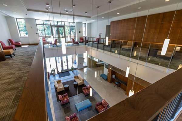 Looking down into the two-story open lobby and seating area with bright lighting and large windows