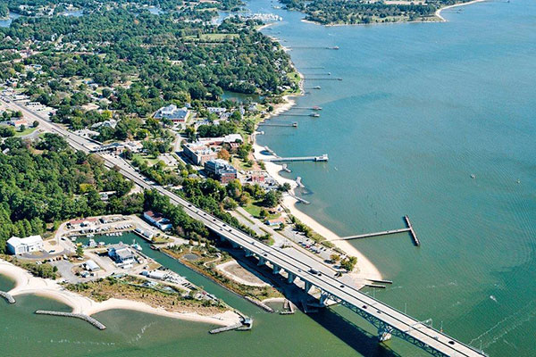 Aerial view of the partially-wooded VIMS campus on the banks of the York River with multiple inlets and docks
